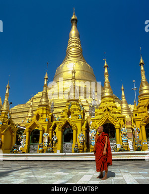 Shwedagon-Pagode, Mönch stand vor der goldenen Stupa und den goldenen Chedis, Rangun, Yangon Region, Myanmar, Birma Stockfoto