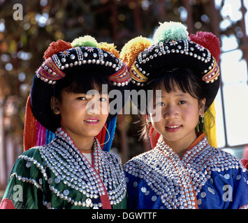 Zwei Lisu Mädchen tragen bunte Kopfschmuck und die Tracht der Bergbewohner, Mae Sai, Chiang Rai Province Stockfoto