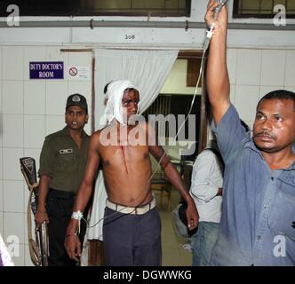 Dhaka, Bangladesch. 26 Okt, 2013. Ein Kollege hilft Alal, ein Fahrer eines auto Rikscha, zu einem Operationssaal in Dhaka Medical College Hospital, nachdem er in einem Bombenattentat in Dhaka, Oktober 26, 2013 verletzt wurde. Pro-Streik Aktivisten warfen rohe Bomben, mutwillig zerstört und das Feuer auf mindestens 13 Fahrzeuge und mehr als 50 Menschen in Dhaka verletzt wurden. Bangladesh Nationalist Party (BNP) und die Verbündeten für drei Tag landesweite Streik von Sonntag genannt wird, eine geschäftsführende Regierung fordert, die lokalen Medien berichtet. Stockfoto