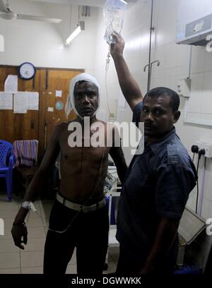 Dhaka, Bangladesch. 26 Okt, 2013. Ein Kollege hilft Alal, ein Fahrer eines auto Rikscha, zu einem Operationssaal in Dhaka Medical College Hospital, nachdem er in einem Bombenattentat in Dhaka, Oktober 26, 2013 verletzt wurde. Pro-Streik Aktivisten warfen rohe Bomben, mutwillig zerstört und das Feuer auf mindestens 13 Fahrzeuge und mehr als 50 Menschen in Dhaka verletzt wurden. Bangladesh Nationalist Party (BNP) und die Verbündeten für drei Tag landesweite Streik von Sonntag genannt, fordern Sie eine geschäftsführende Regierung, lokale Medien berichteten Stockfoto