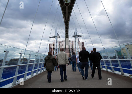 Manchester, Großbritannien, 26. Oktober, 2013. Manchester United Fans an den Kais, Trafford Park, Manchester cossing der Millennium Suspension Bridge. Stockfoto