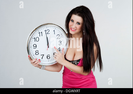 Frau-Holding-Uhr mit den Händen um Mitternacht Stockfoto