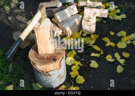 AX Holzhacken auf Hackklotz. Herbst Blätter Stockfoto