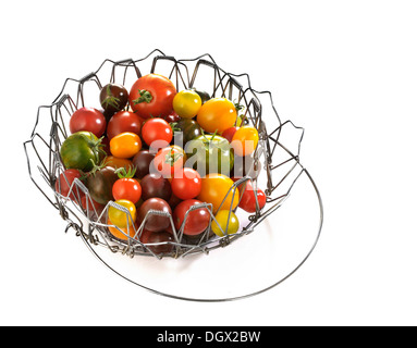 Verschiedene wilde Tomaten in einen Drahtkorb Stockfoto