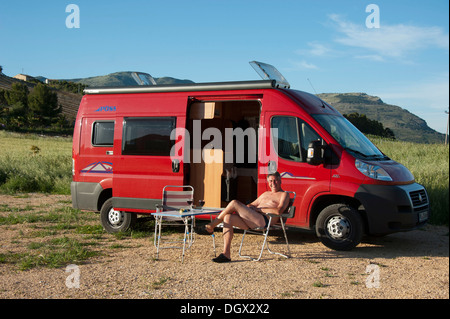 Man sitzt vor einem Campervan, Segesta, Provinz Trapani, Sizilien, Italien, Europa Stockfoto