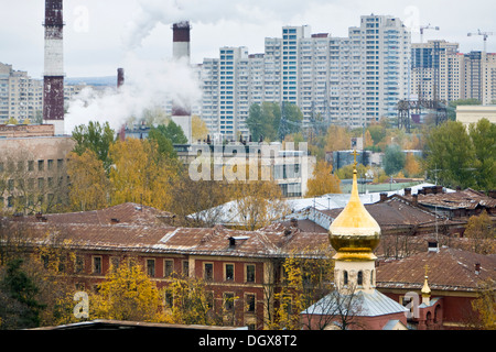 Blick über eine alte Wohnviertel mit Kirche und Industrieschornsteine Hochhäuser mit Fertighaus Betonplatten gemacht Stockfoto