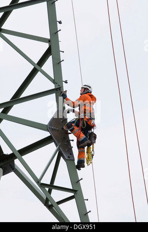 Arbeiten mit einem Drahtseil Kran auf einer 380-kV-Fernleitung Lineman im Besitz der Übertragungsnetzbetreiber 50Hertz, verfolgen Stockfoto