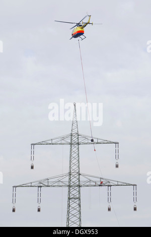 Arbeiten mit einem Drahtseil Kran auf einer 380-kV-Fernleitung Lineman im Besitz der Übertragungsnetzbetreiber 50Hertz, verfolgen Stockfoto