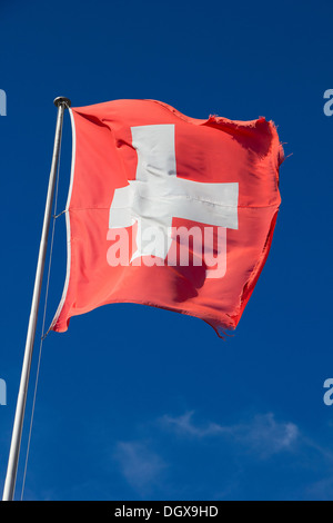 Schweizer Flagge gegen blauen Himmel Stockfoto