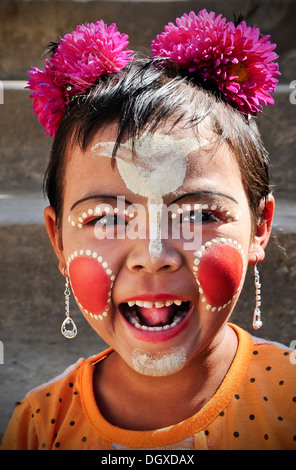 Mädchen, lachen, mit Blumen im Haar, ihr Gesicht ist bemalt mit Thanaka-Creme, Bagan, Burma, Myanmar, Südostasien, Asien Stockfoto