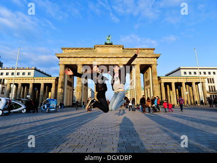 Springen vor Freude, zwei Mädchen springen in der Luft vor dem Brandenburger Tor, Berlin Stockfoto