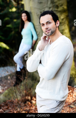 Junger Mann mit einer jungen Frau lehnte sich gegen einen Baum an der Rückseite, Österreich Stockfoto