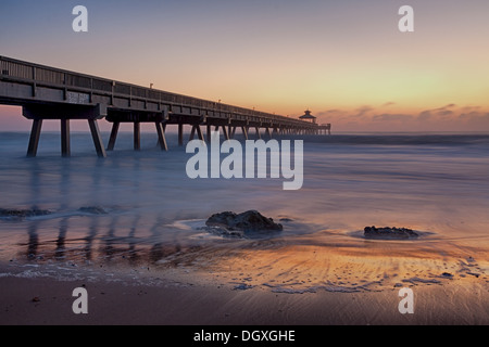 Ein ruhiger Moment vor der Dämmerung am Deerfield Beach Pier mit Rocky Shoreline und ruhigen Meereswellen in Florida Stockfoto