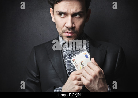 Eleganten Mann fünfzig Euro-Banknoten in seinem Jackett versteckt Stockfoto