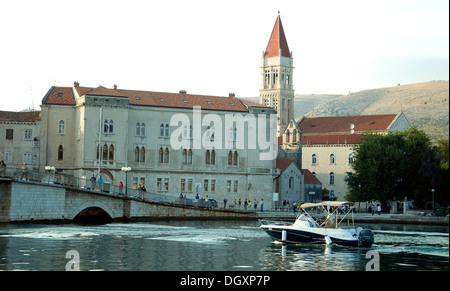 In der Abenddämmerung nähert sich ein kleines Motorboot der eleganten Altstadt und Hafen von Trogir in der Nähe von Split in Kroatien Dalmatien Stockfoto