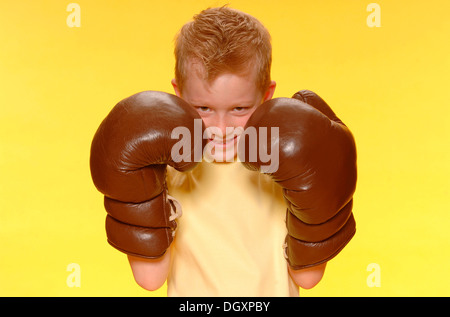 Junge, 6, tragen übergroße Boxhandschuhe Stockfoto