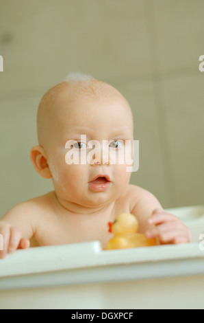 Baby in einem Bad mit Schaum auf dem Kopf Stockfoto