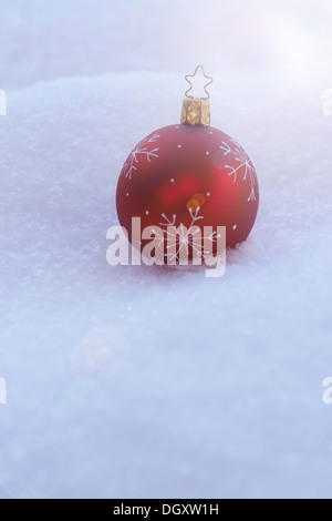 Rote Christbaumkugel im Schnee liegen Stockfoto