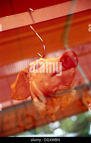 Schweinskopf in einem Schaufenster an einem Haken Stockfoto