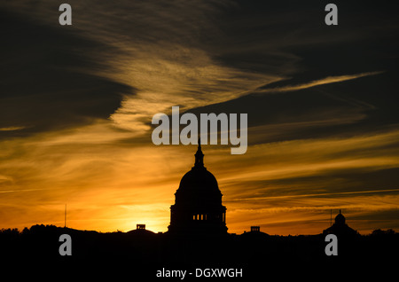 WASHINGTON DC, USA – die Sonne geht hinter einer Silhouette der Kuppel des US Capitol Building (Congress) in Washington DC auf und beleuchtet die Lichtwolken. Stockfoto