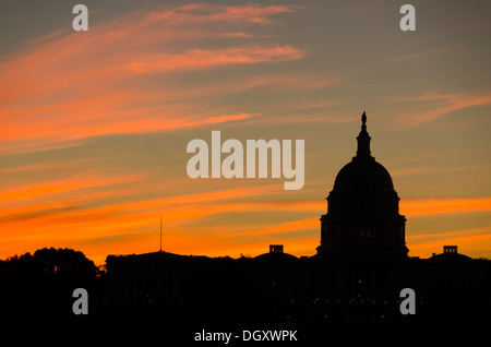 WASHINGTON DC, USA – die Sonne geht hinter einer Silhouette der Kuppel des US Capitol Building (Congress) in Washington DC auf und beleuchtet die Lichtwolken. Stockfoto