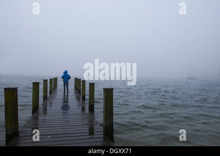 Junge stand auf einem hölzernen Steg im Nebel, Starnberger See, Starnberg, Upper Bavaria, Bavaria, Germany Stockfoto