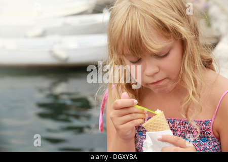 Kleines blondes Mädchen isst Eis. Outdoor-Sommer-Porträt Stockfoto