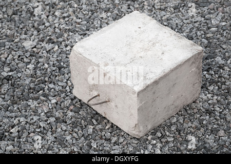 Großer Betonbau Block mit Metall Lug auf grauem Kies Stockfoto