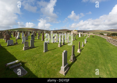 Inseln von Orkney, Schottland. Die Orphir Friedhof mit den Ruinen des Orphir Runde Kirk im Hintergrund. Stockfoto