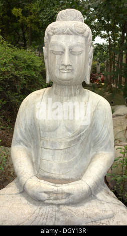 Antike Buddhastatue aus Stein gegen Grün der Wälder Stockfoto