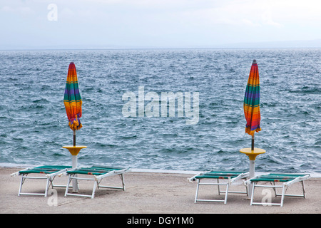 Sonnenschirme und Liegestühle in der Vorsaison auf den Strand von Opatija am Mittelmeer in der Kvarner Bucht, Istrien, Kroatien Stockfoto