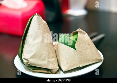 Nasi Lemak Packungen eingewickelt in Bananenblätter und braune Papiere Stockfoto