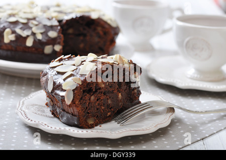 Schokoladenkuchen auf Vintage Teller mit Tasse Tee Stockfoto