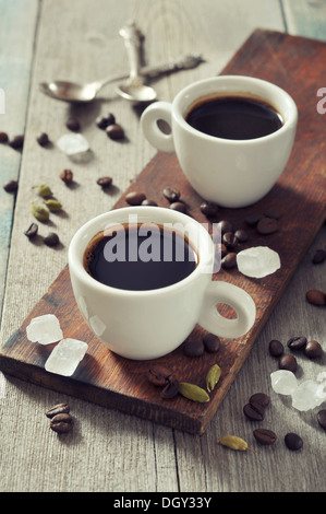 Kaffee in Tassen mit Kardamom und weißen Zucker auf Vintage Holz-Hintergrund Stockfoto