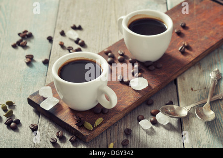 Kaffee in Tassen mit Kardamom und weißen Zucker auf Vintage Holz-Hintergrund Stockfoto