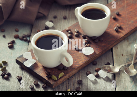 Kaffee in Tassen mit Kardamom und weißen Zucker auf Vintage Holz-Hintergrund Stockfoto