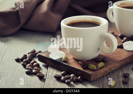 Kaffee in Tassen mit Kardamom und weißen Zucker auf Vintage Holz-Hintergrund Stockfoto
