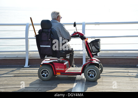 Elderley Mann mit Elektromobil auf Cromer Pier, Cromer, Norfolk, England, Vereinigtes Königreich England, Vereinigtes Königreich Stockfoto