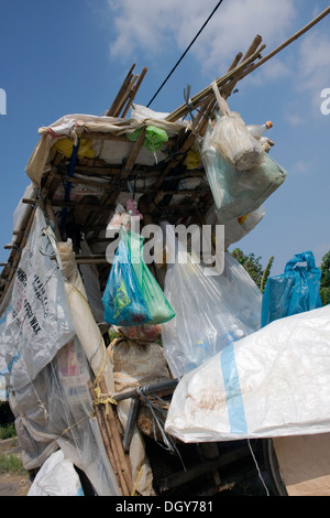 Ein hausgemachte Warenkorb von einem Mann verwendet werden, um Wertstoffe sammeln sitzt auf einer Stadtstraße in Kampong Cham, Kambodscha. Stockfoto