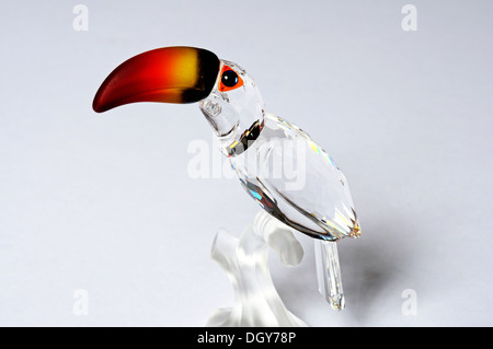 Glas Kristall Toucan sitzt auf einem Ast vor einem einfarbigen Hintergrund. Stockfoto