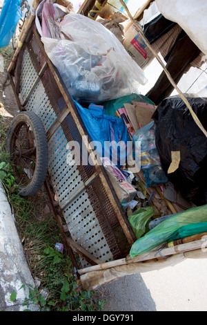 Ein hausgemachte Warenkorb von einem Mann verwendet werden, um Wertstoffe sammeln sitzt auf einer Stadtstraße in Kampong Cham, Kambodscha. Stockfoto