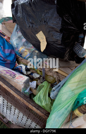 Ein hausgemachte Warenkorb von einem Mann verwendet werden, um Wertstoffe sammeln sitzt auf einer Stadtstraße in Kampong Cham, Kambodscha. Stockfoto