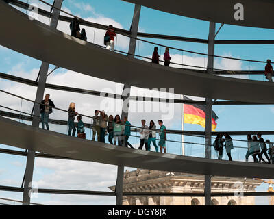 Besucher in der Kuppel des Reichstagsgebäudes und die deutsche Nationalflagge, Berlin Stockfoto