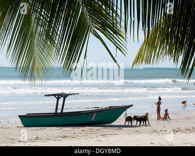 Boot, Costa Rican Frauen und Hunde an den Strand, Playa Samara, Halbinsel Nicoya, Costa Rica, Mittelamerika Stockfoto