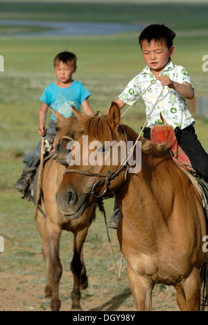 Zwei kleine 6-j hrige mongolischen jungen brechen temperamentvolle Pferde Mongolisch in Trockenrasen, Lun, Toev Aimak, Mongolei, Asien Stockfoto