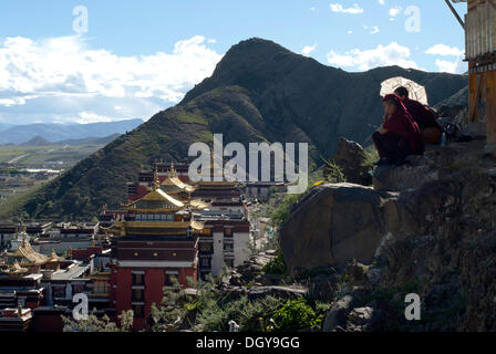 Tibetischen Nonnen ruhen auf einen Rundweg der Kora-Wallfahrt über den Dächern des Klosters Tashilunpo in Shigatse Stockfoto