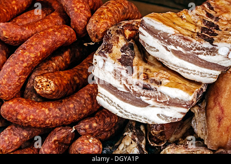 Stücke von geräuchertem Schweinefleisch Speck überlappend, zusammen mit Würstchen. Stockfoto