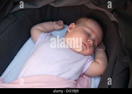 Kleines Mädchen schläft in ihrem Kinderwagen draußen Stockfoto