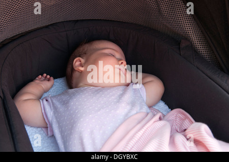 Kleines Mädchen schläft in ihrem Kinderwagen draußen Stockfoto