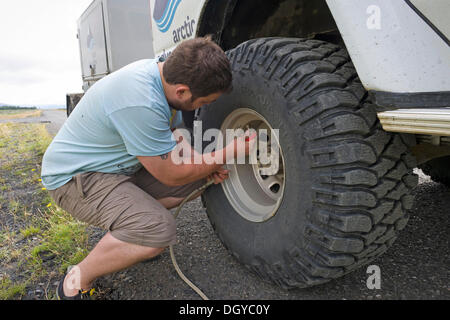 Super-Jeep Fahrer Überprüfung der Reifen Druck, Island, Europa Stockfoto